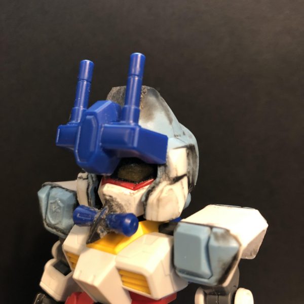 ガンダイバー製作中です。写真一枚目が最新状態です。改造手段は基本的に接着剤の貼り付けとプラリペア（黒粉）による整形です。脚SDCSガンダムの足パーツ（中央）にhg AGE1の脚を左右切り落として貼り付け。今更ながらSDCSシスクードの脚があれば良い事に気付いてしまった。腰アーマーSDCSガンダムの腰中央パーツにhg キマリスのパーツを移植。左右のスカートはhg アストレアから。頭部ガンダイバーの顔くり抜いて、中の空洞にSDCSガンダムの顔面部を付けました。具体的にはガンダイバーの頭（カブト）に大量のプラリペアを流し込み、SDCSガンダムの接続パーツを埋めこみました。カブト部分と口元をカツラギさん仕様に整形中。（3枚目）