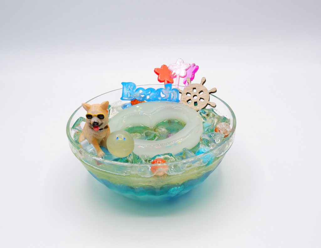 夏っぽいディスプレイということでこのようなものを作ってみました!ゼリーのようなひんやりとおしゃれなものを作りました2液レジン初挑戦!!最下層と中央に浮いている(ように見せたい)ハートがの穴が空いている浮き輪(のつもりのもの)は最初に作った部分で盛大に失敗したもので白濁となってしまいました!2、3層はしっかり学んでなんとか透明な状態にできてクリアーブルー、イエローをそれぞれ混ぜて作りました!