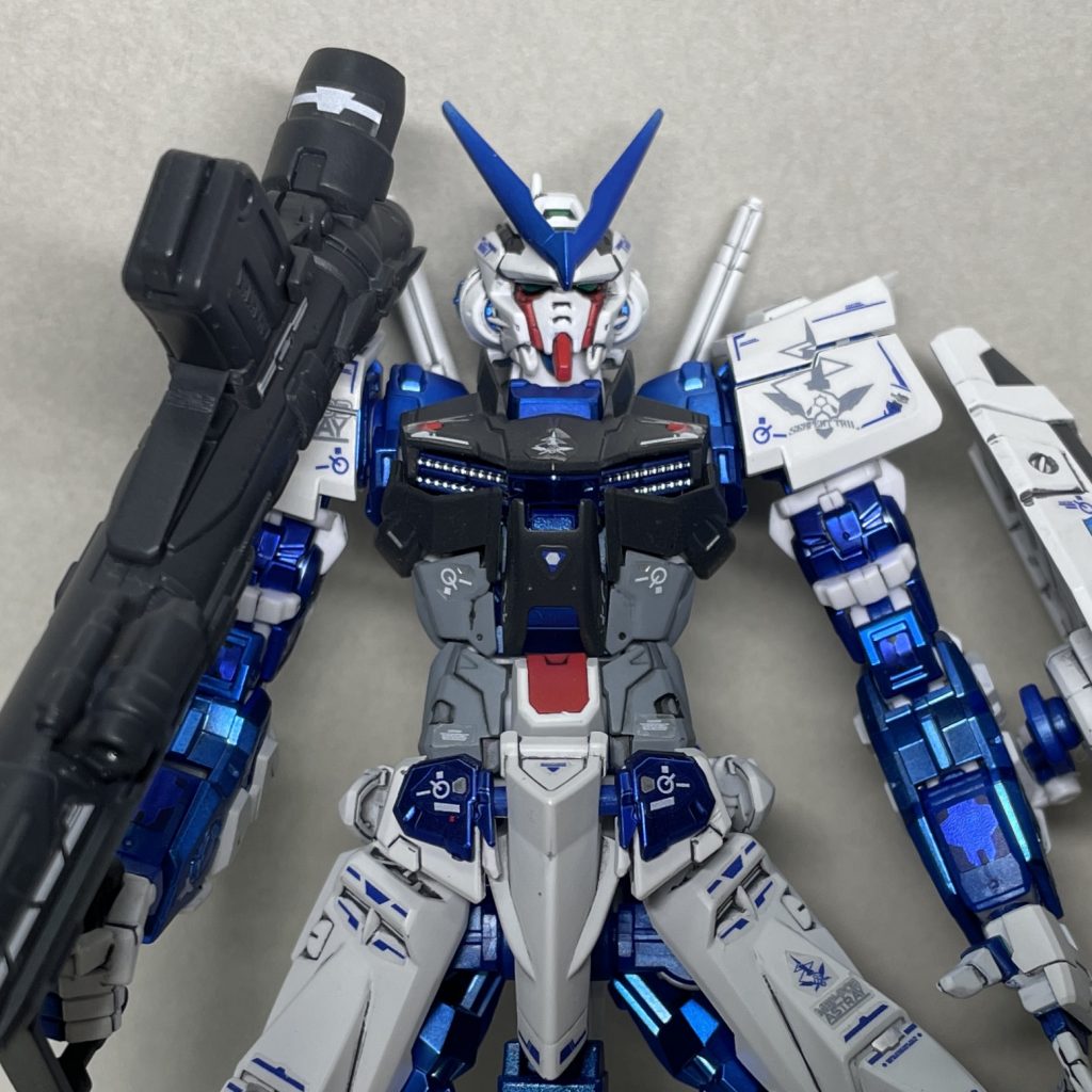 上半身アップ 付属シールは、ほぼ指定通りに貼りましたが、目の部分のセンサーとバックパックのセンサーの部分は、うまく貼れなかったので塗装しました。 拡大すると、シールの位置決めを失敗して貼り直した箇所がバレバレです。一度圧着した後にはがしてきれいに貼るのはほぼ無理なので、予備があるならそちらを使った方がいいです。シールの余白が他の面にかかるような場合に余白を切り取るようにしましたが、位置決めしやすかったり、そのままの方がシールがはがれにくいような余白はそのままにしています。腹の下の部分の小さなシールが、一度はがした上に余白をちゃんと切り取っていない失敗例です。本来は面をまたがないようにギリギリまで余白を切り取るべき箇所ですが、今回は横着してそこまで突き詰めませんでした。シールを貼った後、シールを貼った部分にクリアーを吹き、その後全体をフラットクリアーでトップコートしてツヤを落としました。