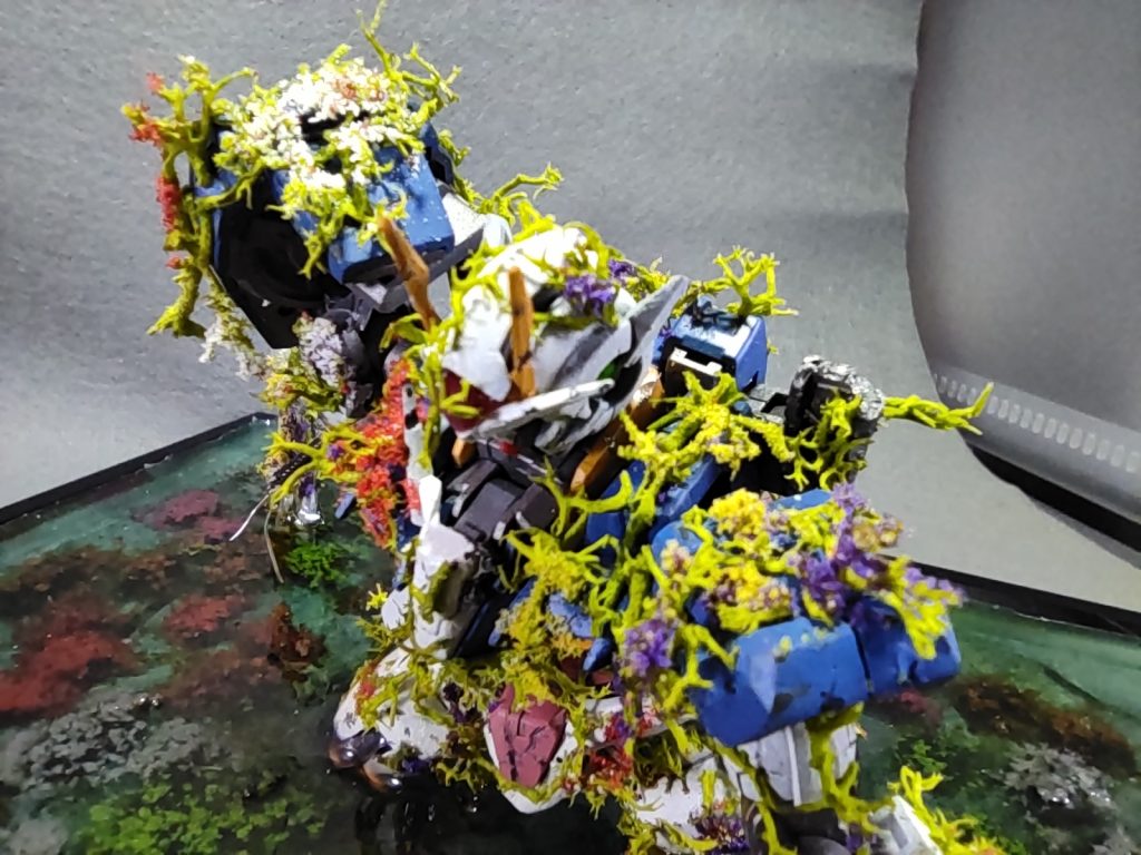 エンディングイメージを再現するにはなんと言っても機体に絡みついた華や蔦。コレの表現には色々と悩み、Amazonや様々なサイトを参考にした結果無難に「ミズゴケ」と「パウダー状の花」、「草むらと花セット」の三点セットに落ち着きました。機体に絡む蔦は「ミズゴケ」を細かくバラして瞬着や木工ボンドを点着けしピンセットで止めていくという地味な作業になりました。機体に咲く華は点着けした「ミズゴケ」に木工ボンドを水で溶いたモノを筆でチョン塗りし「パウダー状の花」をまぶしてそれっぽくしました