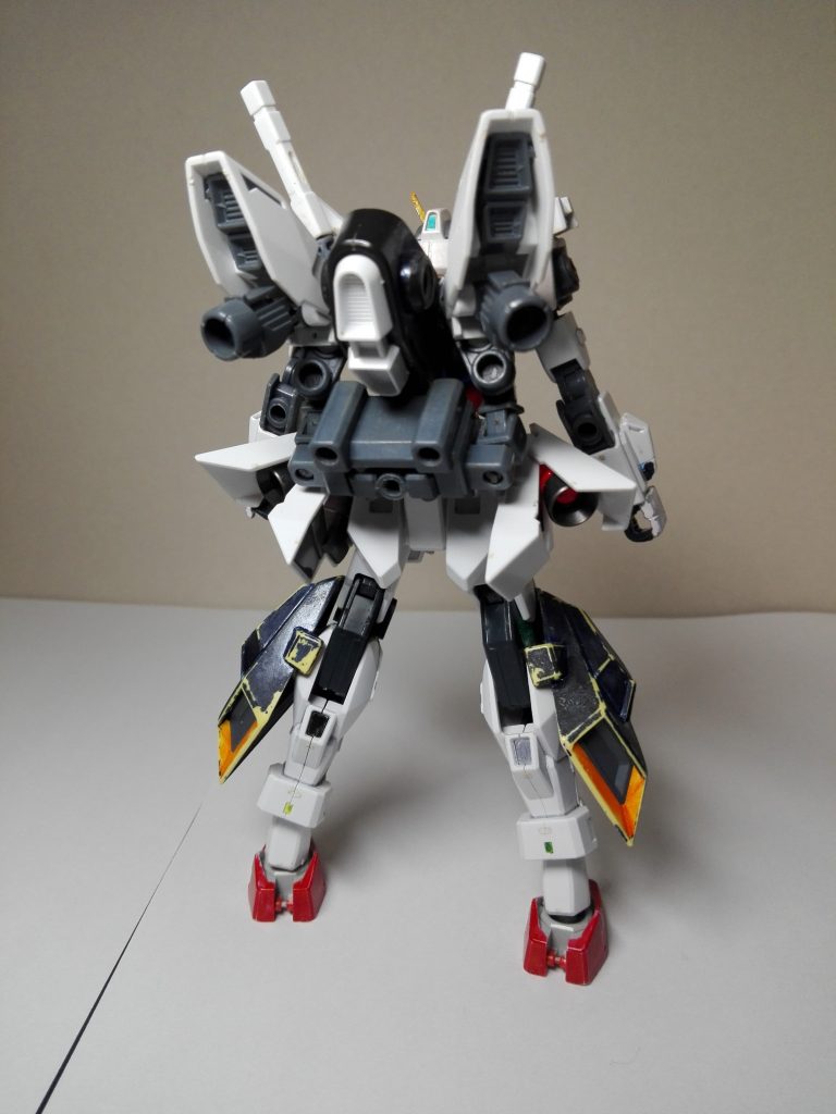 後ろ側から。背中から斜め下に向かってバックパックが付いており、そこからサーベルラックが伸びています。中央のユニットは2穴ジョイントで換装でき、太陽炉なども装備できます。両腰のスラスターを展開することで爆発的な加速を得ますが、機体が耐えられず空中分解するでしょう。3mm穴も各所にありますが、関節が保たないので基本的に何も付けません。