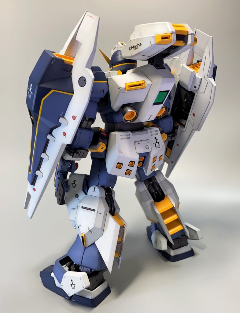 バックショット設定と異なりますが、フレームが見えないようにスネ外側切り欠きはなくしました。バーニアをプレゼントキャンペーン品に変更。バックパック中央緑のセンサーをプラ板で作成。「OMecha」デカールは自作。パーソナルマークは空山氏作例で貼っていないため、貼らないことを選択。ソール形状変更も検討しましたが、これはこれで独特で良い気がしたので、キットそのままを採用。