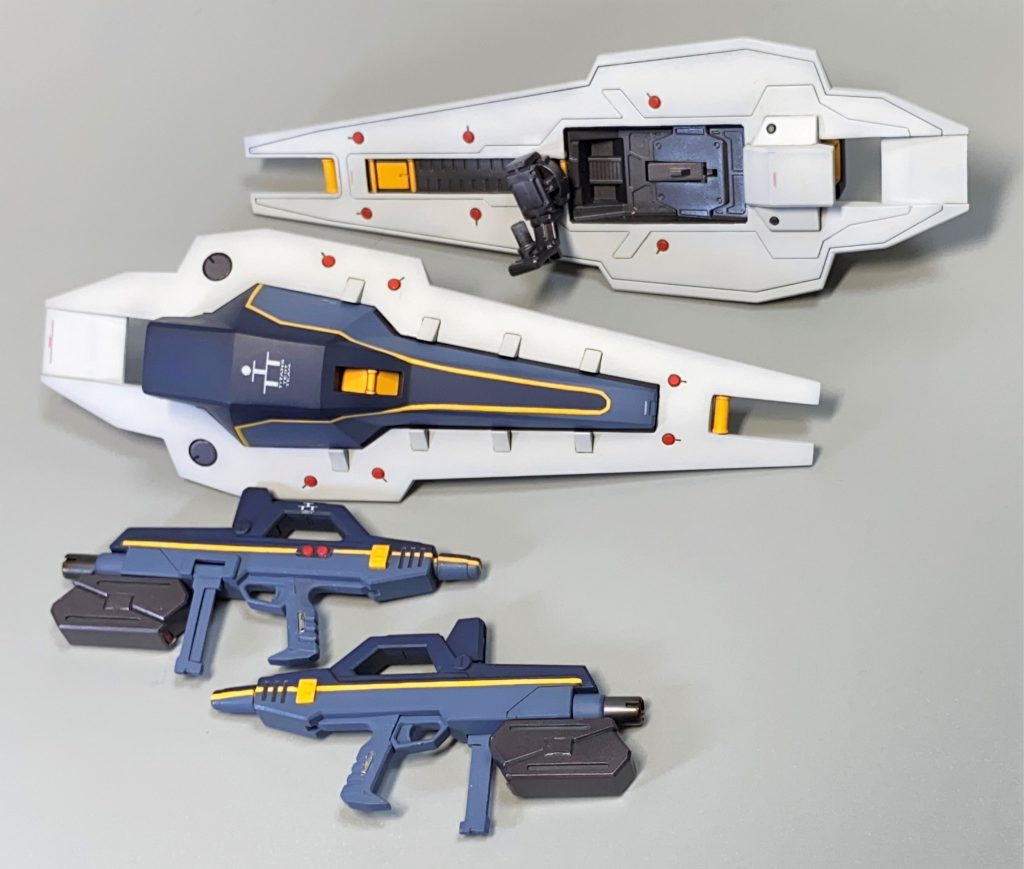 ライフルグリップに磁石埋め込み。ライフル右側面にはスイッチモールドが無いのが正解なので形状変更。キットにはないシールドブースターのフィンモールドを彫り込みで再現。下部のオレンジバーは一度切り離して塗装後に再接着。コの字型のシールド接続パーツはそのまま使うと邪魔になり、腕が広がってしまうためL字型に加工。ライフルは処理と塗装を考えて分割を変更。銃口を二重構造に加工。