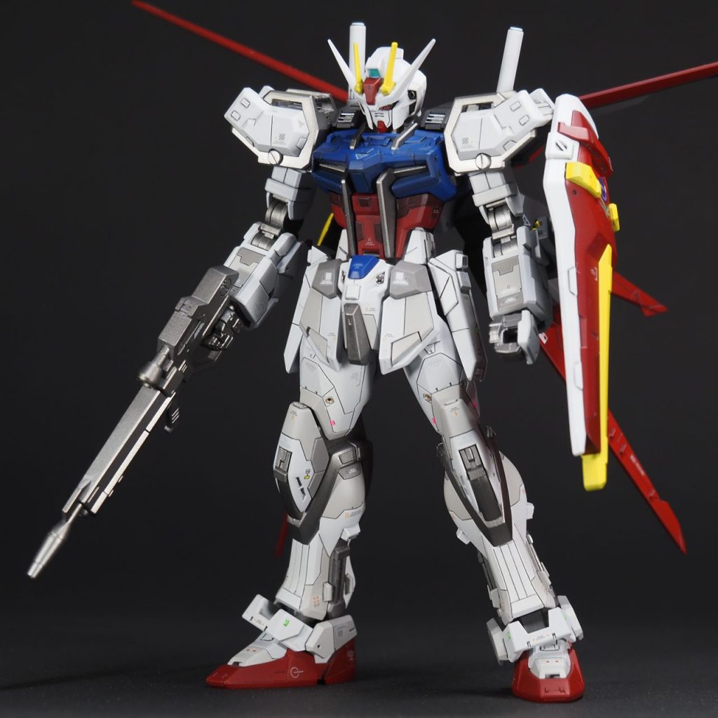 全身にスジボリ、プラ板でのディテールアップ、パネル色分け、レッドチップ貼り付け、メタルパーツ少々、といういつものメニュー。それに加えて今回は、プラ板の厚みを活かして走行の厚みを増す加工をいくつか施しました。肩パーツ、フロント腰アーマー、アンクルガードなどです。ふくらはぎの左右と腰アーマー左右には、スクラッチした四角いスラスターを増設してあります。