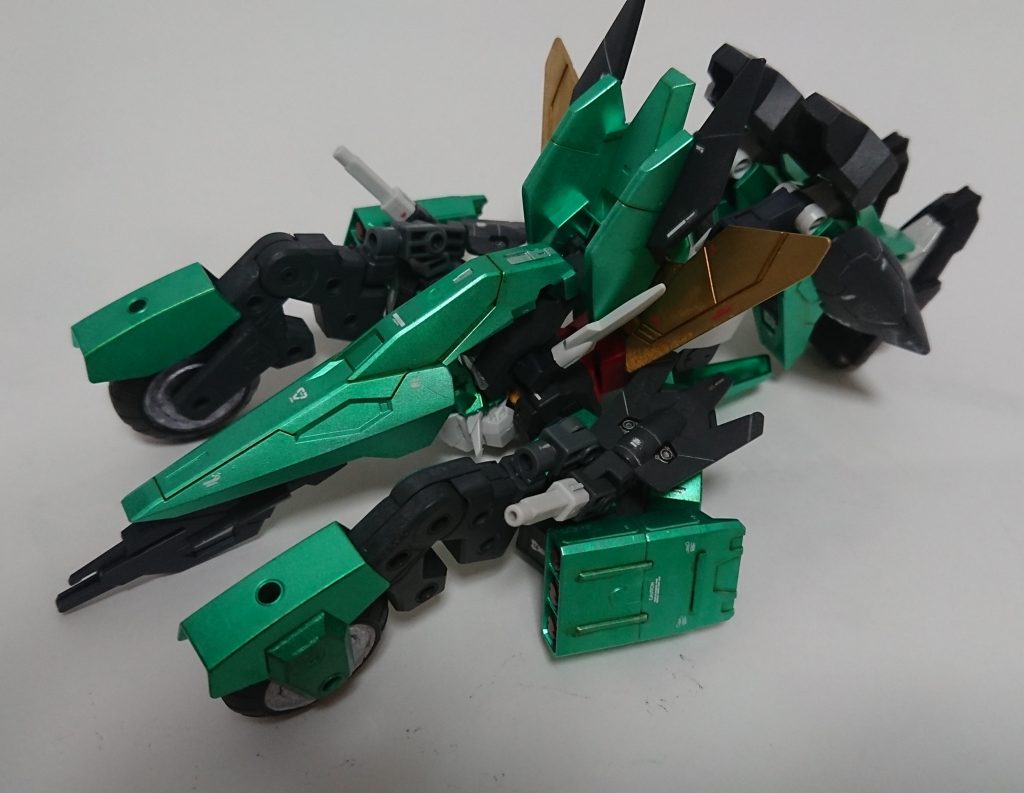 ひっくり返したら、フライヤーユニットを頭を覆うように回転させて、タイヤ、武器の位置を調整しつつ、脚を曲げて踵のタイヤが地面に接地するようにすれば変形完了です。