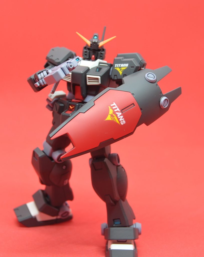 武装してリブート2巻の表紙では「レジオンのエンブレム」のシールドを持ったジムクゥエルと、左肩に「ティターンズのエンブレム」を持つアーリーヘイズルが描かれていました。電撃ホビーで掲載されていたジムクゥエルの作例では、シールドと左肩の両方にレジオンのエンブレムが描かれていたことを考えると、おそらく表紙の二機は「レジオンのジムクゥエルとティターンズのアーリーヘイズルが背中合わせで立っている」という構図で、だからエンブレムが違うのだと思われます。とすると、アーリーヘイズルのシールドでは、レジオンのエンブレムがある場所にティターンズのエンブレムが描かれているのだろう、ということでこのように。アーリーヘイズルのシールドのカラー設定画が欲しい所です