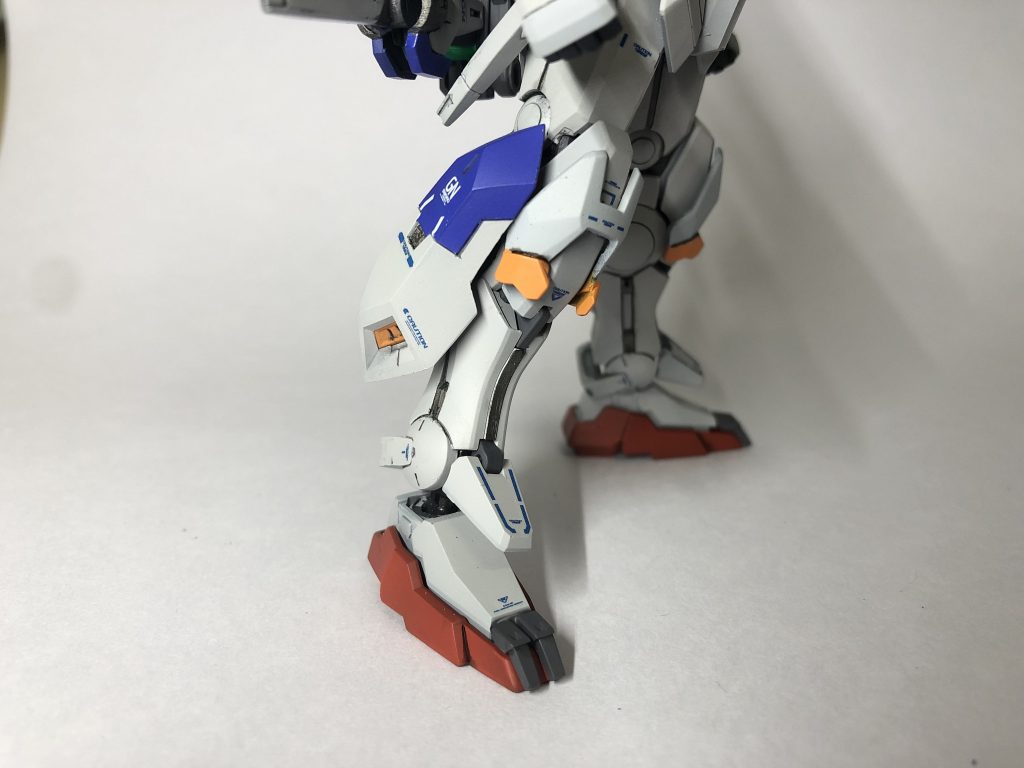 脚部には大型のスラスターを追加しました。これにはGNフィールドを前方に展開する機能があり、敵機との間合いを詰める際に使用します。爪先にはGNクローを装備することで蹴りを行う際の破壊力と本機体への衝撃緩和を図っています。