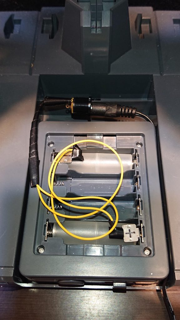 youtubeで電池ボックスのACアダプター化しているのを見て真似しました。自分は穴を開けたり、基盤にはんだ付けする程の技量が無かったので、ACアダプターソケットと100均で買ったシーラーを分解して取り出した電池金具を銅線で繋いだものを、単4を単3にする電池スペーサーで電池ボックスに押さえつけてコンセントから給電出来るようにしました。