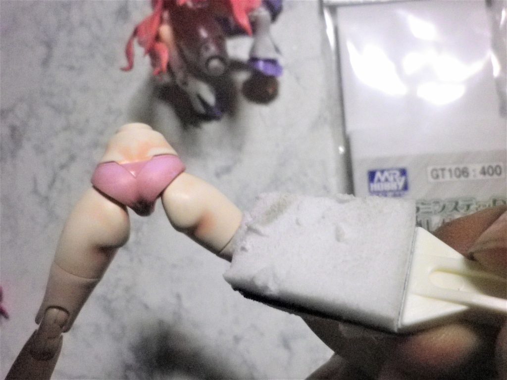 カラーレシピは次の通りです。髪パーツ 下地色 GXクリアピンク、中間色 トランザムハイライトレッド、ハイライト色 ピンクプラス少量の蛍光ピンク上着(白)パーツ 下地色 タミヤラッカーシルバー、中間色 アルティメットホワイト、ハイライト色 ダイアモンドシルバー、トップコート色 スムースパールコートスカートパーツ 下地色 GXメタルパープル、中間色 アルティメットホワイトプラス少量のクリアーパープル トップコート色スーパースムースクリアー袖、ミニスカートパーツ 下地色 純色バイオレット、中間色 ラベンダー、トップコート色スーパースムースクリアー肌色パーツ 下地色 ホワイトピーチ、 中間色 クリアーペールレッド、 トップコート色 スムースパールコート細部はガンダムマーカー等でタッチアップ塗装です。完全乾燥後に凸部分を本来はAFVのつや消し仕上げ用に使う”Mr.メラミンスティック”を使って研磨、下地色が表面に出たところでコート色で保持してハイライトとしています。