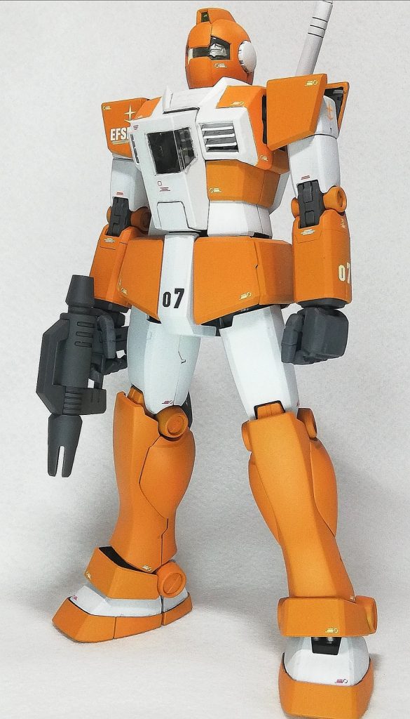 全体像。いつもどおりのプラ板、ポリパテにより製作しています。頭部: バルカン砲をプラ板とパテで埋め、おでこはプラ板で製作。腕部: 肩は上面が無い状態なので削除するのですが、全削除してしまうと強度的に怪しかったので付け根を残して削除しフレーム色と同じにする事でごまかしています。胴体: この機体の特徴的なコクピットは外観はプラ板で、ガラス部はおかずで出てきたお刺身盛り合わせのフタを切り抜いて製作しました。コアブロックは複座式にしてパイロットも2名組み込んだのですが完成したら1人しか見えなくなりました。塗装は、ジム・ライトアーマーのホワイトと黄橙色に赤を加えたもの。デカールを貼りクリアコートの後、Mr.ウェザリングカラーのグレーとイエローでウォッシングして完成させています。