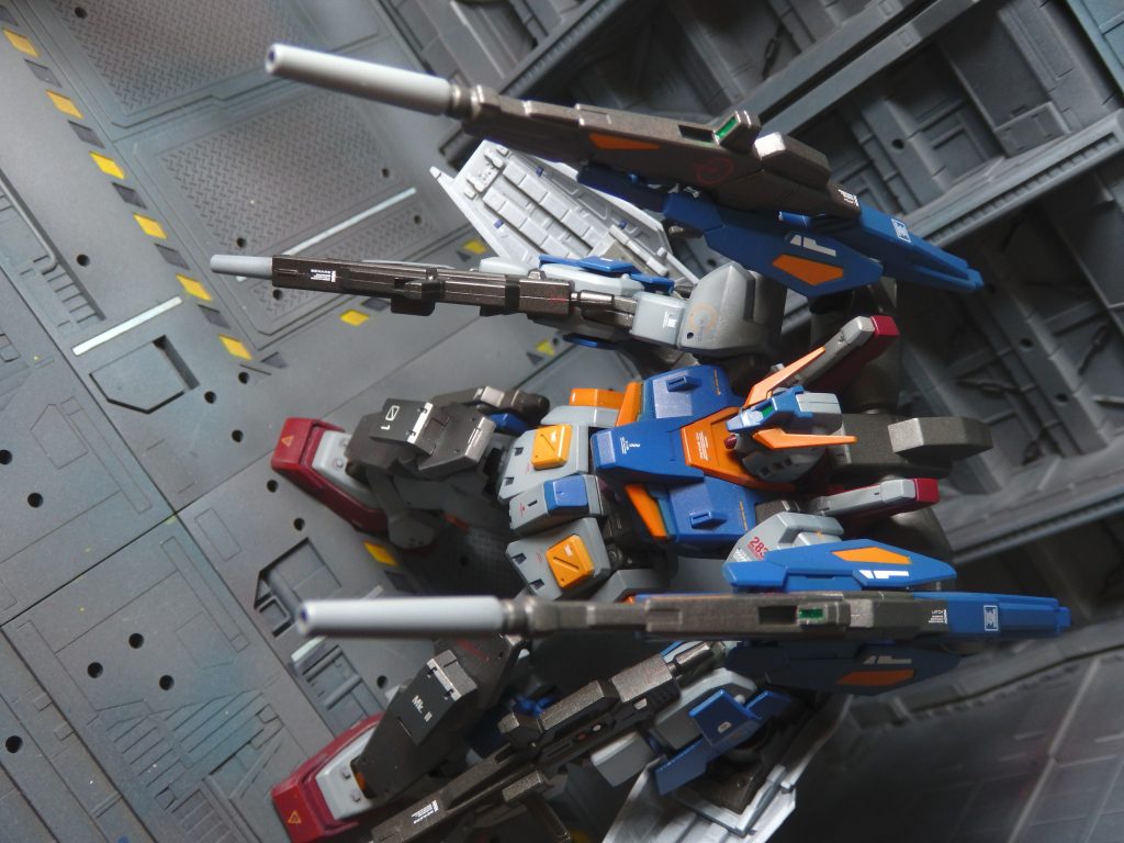 ちょっと長いのですが、制作の経緯をお話します。BGMK2はシールド一体型のビームライフルを前腕に装備したり、手持ちにしたりする仕様です。頭部のアンテナがもっさりしているのと相まって、好みではないなぁと思っていました。その為、発売当時はスルーしていました。先日、GFFのガンダムMK2の中古品が一部パーツ欠品の為、格安だったので購入しました。欠品は腰のアーマーで、これはHGUCのパーツを使えば補えるかなと思い、中古のガンダムMK2を探しに駿河屋さんに行きました。あいにく安いMK2は見つからなかったのですが、このBGMK2がありまして、よくよくビルドブースターMK2のデザインを見てみたら、あ、これガンキャノン的なやつじゃないかと気が付いてしまいました。バックパックに接続したライフル２丁を肩越しに構えられるのなら、大好物のキャノン系のシルエットになるので、これはこれで何かに使えると思い購入し、腰アーマーは予定通りGFFの修復に使いました。元々パワード・ジムの腰アーマーが余っていて、何かに使いたいと思っていた所だった為、MK2＋パワードジムの腰アーマー+アルファでミキシングしてオリジナルMSを作ろうと思いついたのでありました。制作ストーリーも投稿しておりますので、是非ごらんください。最近は制作スピード重視でデカールを使っていなかったのですが、久々にモリモリ貼ってみました。中々にカッコイイ機体が出来上がったと自画自賛しております。シールドを装備した為、結局、腕が重そうになっちゃいましたが。ご覧いただきありがとうございます。