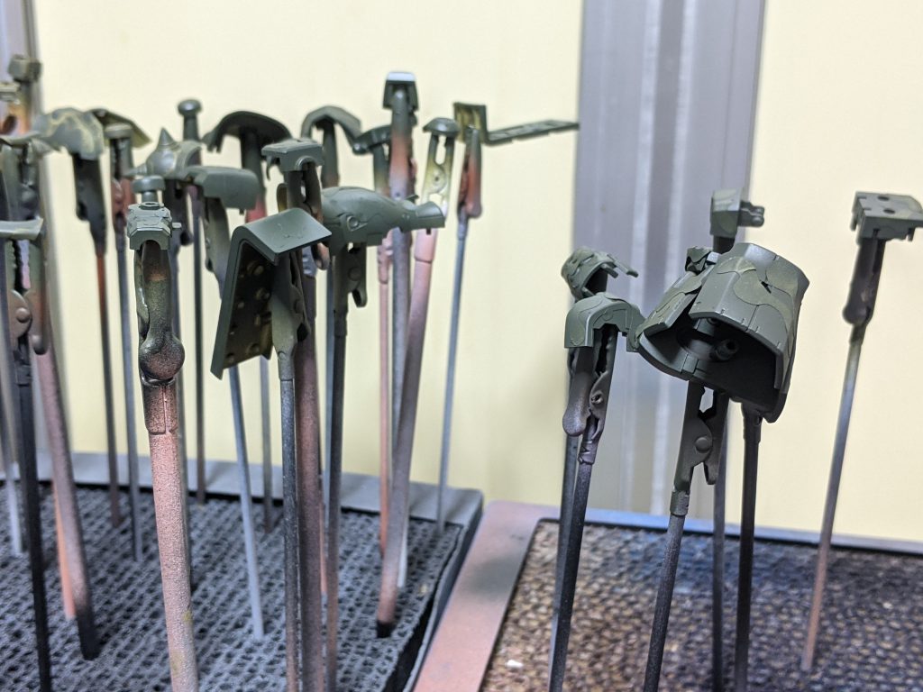 ベース色を成形色の明るい色のパーツと暗い色のパーツにそれぞれダークイエローやレッドブラウンを塗装し、クラウド迷彩用マスキングテープを貼り、2色目の濃緑色を塗装した状態です。