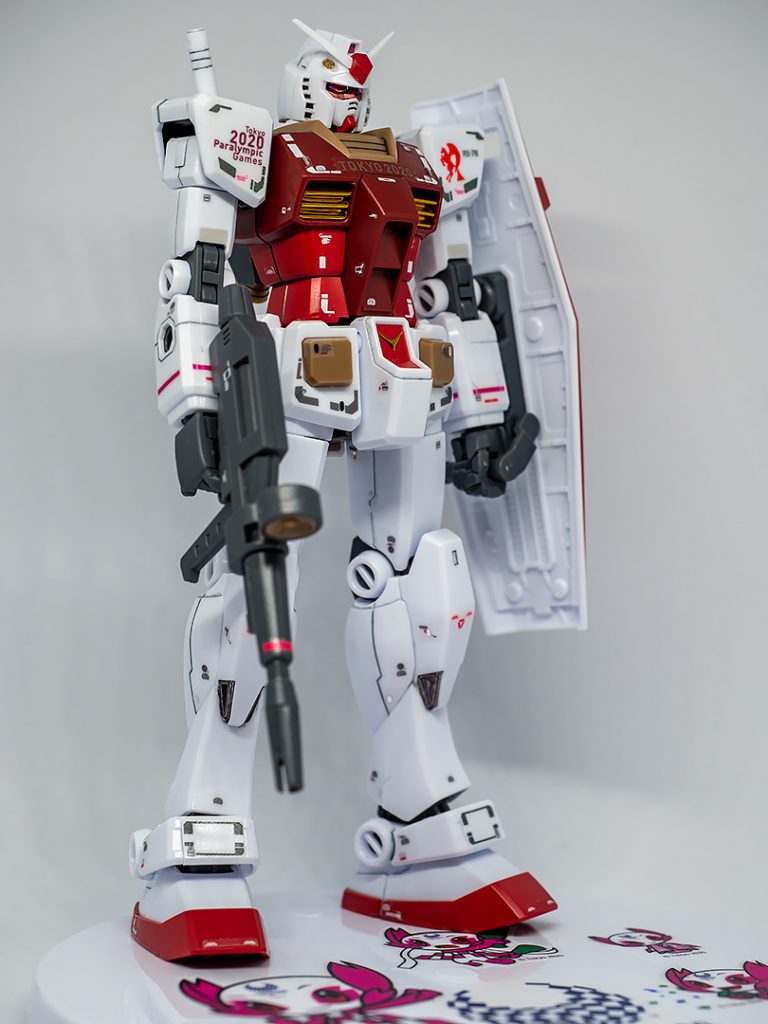 こちらのツインアイはHQパーツの円形シール(メタリックピンク)の余白をRGのシールを型紙にして切り抜いて貼っています。先行して貼ったオリンピック版のシールの浮き具合がちょっときついかなと思ったので「箔」の少ない腰から上は水転写デカールを使いました。(胸の「箔」はRGのシールにこの部分だけのシールがあるのでそちらを使用)