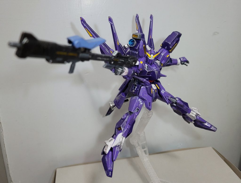 はい、以上ですバニシングガンダムmk-Ⅲでした自分は世代的にスパロボF~αの時代、即ちあのバニシングトルーパーの全盛期が直撃だったのでmk-Ⅲと言ったらどうしても凶鳥の方が先に頭に浮かんだのです珍しくプレバンに注文できたものの機体自体は特別なデザインもギミックもないのでどうやって作っていくか悩んだまま仮組み状態で6月からしばらく放置した頃ゼットコン開催したのを見てこちらでエントリーすることを決めて他の積みプラを一旦止めてこちらに専念しました以下改造の詳細です頭部:mk-Ⅲのアンテナは不採用ビルダーズパーツでアンテナと耳?を新造胴体:胸部や腹部は無改造フロントスカートはmk-Ⅲじゃなくテルティウムの方を採用サイトスカートにライフルを付けるための磁石を接着ビームキャノン/サーベルを保持するための突起をプラ板で追加リアスカートにはシールドをマウントするための磁石を接着(本来のライフル穴は廃止)左右にビルダーズパーツのバーニアを追加腕:元ネタのマッシブ感を出すためにウィンダムの肩を上乗せさらにその下でビルダーズパーツのバーニアを追加足:無改造バックパック:下の方のバインダーを逆にして上に向かせたこれで可動を殺すことになるがシルエットがカッコいいビームキャノンの付け根部分も逆にし、その上にバーニアを追加設置したさらに、キャノンはサイトスカートに移設されたのでそれを付けるための穴にはバーニアを追加(テキストで説明が難しいので写真の3・4枚目を見ていただければ…)ビームライフル(細い方):サイトスカートにマウントするために磁石を接着写真では右にしかマウントしてなかったけど左右のどちらにも装着できるビームライフル(太い方):こちらも磁石を接着して左右サイトスカートにマウント可能にビームライフルを2丁も携帯する意味を見出さなかったのでこちらには設定を盛ってグラビトンバスターに改造スコープはパイプを切断してライフルの真ん中に接着その上に余剰パーツの脛アーマーを被せたそして別のライフルを差し込むための穴を後ろに開口してあるクロスチャージという技名で気付いた人もいるでしょうが元ネタはロックマンX3ですシールド:リアスカートにマウントするために磁石を接着また、無改造だと腕に付ける/外すたびに塗装が剝がれるのでEGガンダムからシールドグリップを移植して手首で持つようにしたファングスラッシャー:基部パーツはアクションベースの接続パーツとポリキャップで作成他の武装と同様、磁石で本体にマウントするのですがどこに付けばいいか結構悩んでいました肘、シールドの裏、リアスカートの真ん中など色々試行錯誤したけど最終的にはリアスカートの側面に落ち着いた