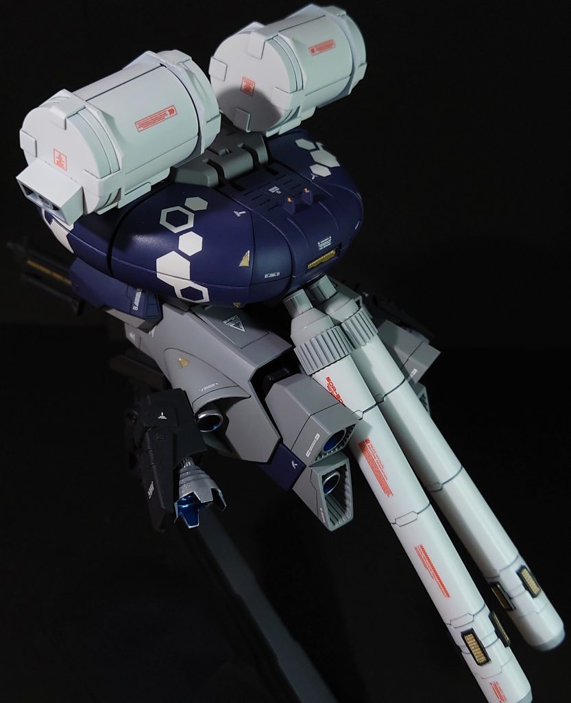 変形時のフロントショット+バックショット。変形機構を残すか、オミットしてプロポーションを変更するかで迷ったのですが、やっぱり可変機ですので、前者を取りました。差し替え無しで変形できる機構の素晴らしさよ。システムウェポンキットのビーム・ライフルはそのままでは、可変時に底部に装着できないので、大型ビーム・ライフルのパーツを切り取って、可変時に装着できるよう改造しています。また、プロペラントタンクを装着するために、バックパックを下げたので、そのままでは大型ビーム・ライフルを装着できないので、本体背部と大型ビーム・ライフルそれぞれに磁石を埋め込んで、くっつける形で装着させています。(上部写真ご参考)肩の合わせ目は段落ちモールドにしまして、可能な限り違和感をなくしています。