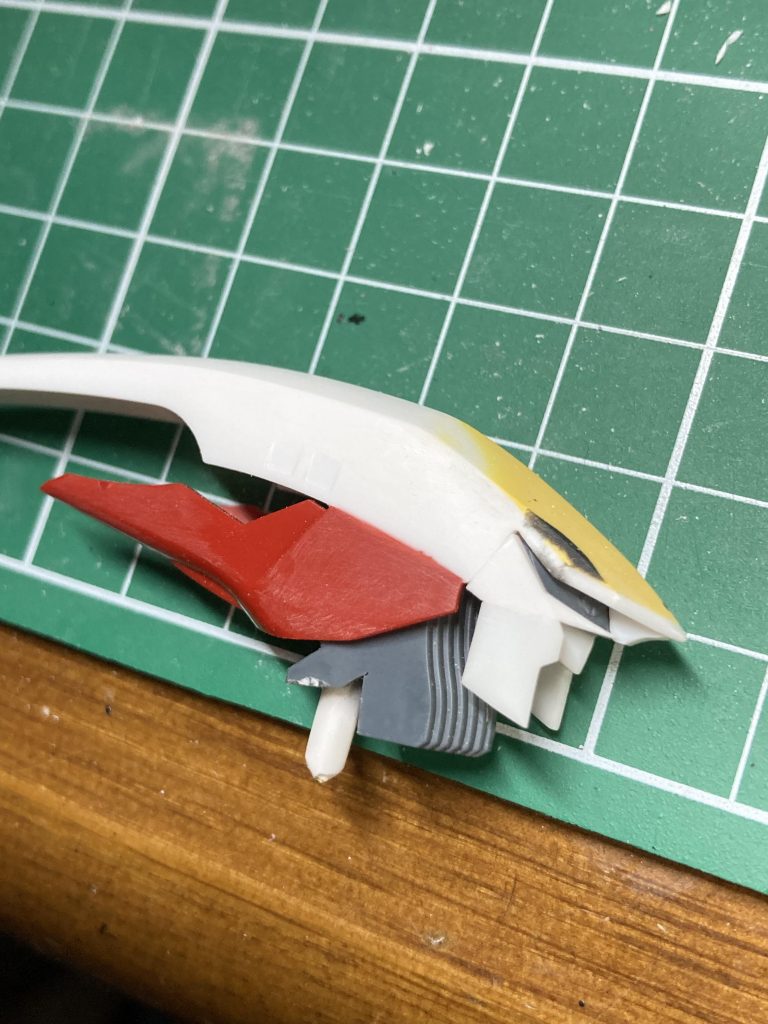 ひさしを大幅に伸ばし、マスクを着け、後頭部の形状も変更しています。赤いパーツはシナンジュのバックパック装甲を切ったものです。