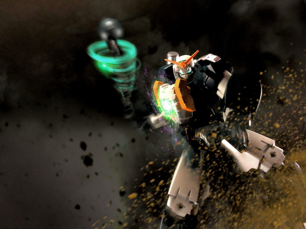 第五章 北の囚人西の都での戦闘が始まり、数時間が経っていた。普段であれば損害が激しければ一つ目の軍団は撤退するが、今回の戦いは何かがおかしい。西の都へ一つ目のMS軍団が向かう最中、大蛇のような何かが地を這って一つ目軍団の跡を追っているのだった。ガンダム達とマックスターボ隊は住民達の避難を確認し、自分達も母艦に乗船しようとした時、地響きと共に大きな地割れが起きる。地割れの中から現れたのは、ガンダムタイプの頭部に蛇のような体をしたMAだった。MAの頭部口元からは強力なビーム砲が放たれ、住民達が乗船している飛空艇一隻に直撃し爆散した。マックスターボ隊は再び応戦し、ガンダム達も戦場に舞い戻った。その後も次々と地割れの中からはMAが生えるように現れ、一つ目のMSの攻撃もあり押され始めていた。万事休すかと思われた時、遠くで渦巻きが如く強烈な風圧が発生していた。その渦は一つ目のMSとMAを巻き込み、巻き込まれた機体は撃破されていく。渦の中心にいたのは北の都のガンダムだった。数日前、北の都は一つ目軍団の襲撃により壊滅されたと連合軍の間で通達があったのを思いだし、マックスターボは渦に近づいてガンダムを確認した。マッシブな体型、胴体部のボルテックコア、名はガンダムボルテックス、まさしく北の都のガンダムだった。