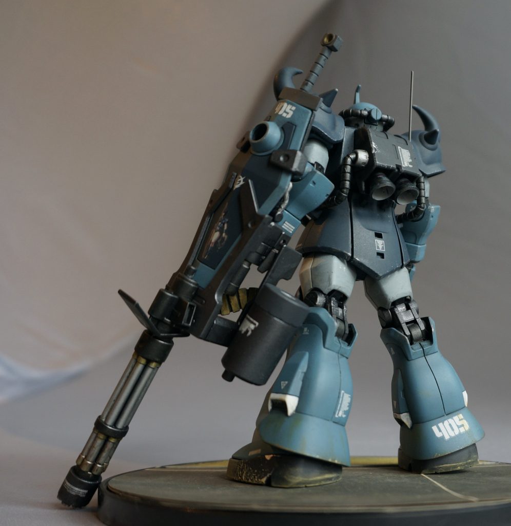 バックバックのバーニアは市販品に置き換え。こちらも うっすら青焼塗装をかけています。また、真鍮線によるアンテナも設置しました。ガトリングシールドには「グフ・レディ」のマーキングを入れました。このマーキング、グフ以外には使えないですよね?(笑左脚のソール側面には塗装前にアルミ箔を接着し、塗装後サンドペーパーで塗装を剥ぎ取り、金属色を露出させるというダメージ加工を入れています。何かにぶつかって歪んだ金属板の雰囲気を狙いました。