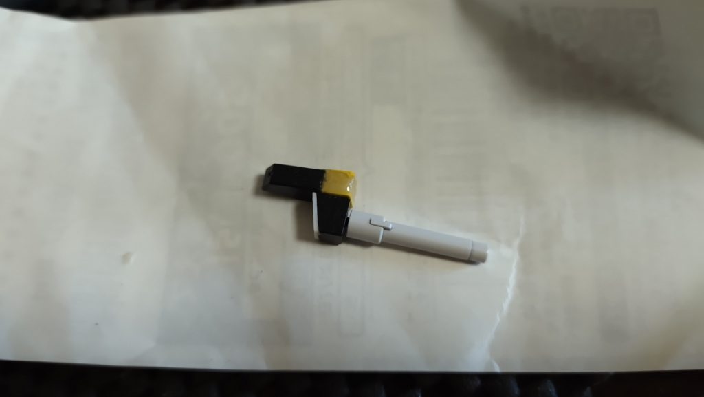 切り離したビームサーベルの刺さる側のパーツの穴をプラ板でふさぎ、元と同じくらいの長さにポリエステルパテで整形、ビームサーベルはそこに横から接着してお手軽にずらしています。あとは以前と同じようにキャノンユニットの上からはめこむだけです。ある日ご飯を食べていたらふっと思いつきましたwしかしこの工作をしているとキット化の際設計した方がビームサーベル位置を敢えてずらした意図が何となく感じられてきました。ずらした後の面が無駄になる感じがするのです。スコープでもあればよかったのですがその設定は無いですし、そもそもスコープは砲の下にあるようですし(ラピーシールを貼りました)デザインの無駄は確かにキットのままのほうが無いような気もするんですよね…設定どおりの方がカッコイイとは思うのですが