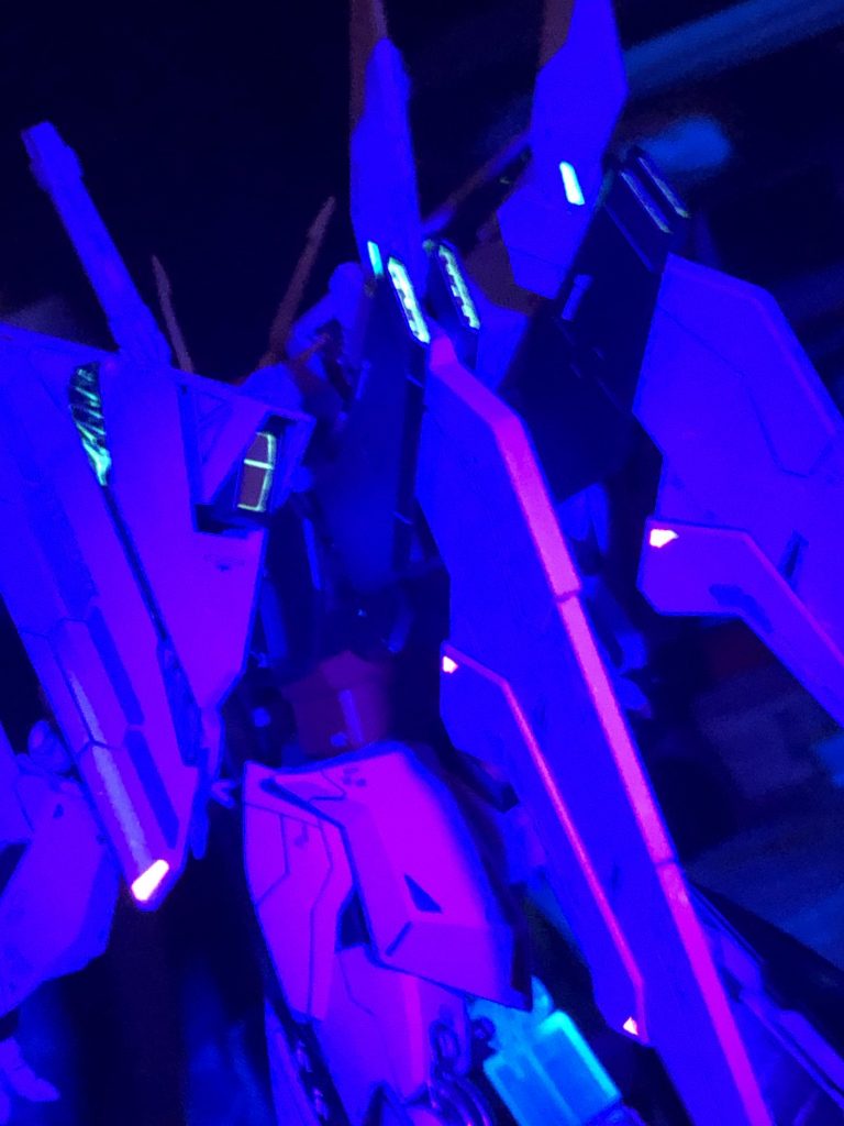 あちこち蛍光カラーで塗ってあるのでブラックライトで光ります。塗装はホワイトは成形色のまま、ブラックはガイアカラー　プリズムブルーブラック、関節はスターブライトアイアン、肘はカッパーにシルバーを少々、オレンジはタミヤメタルオレンジ、赤はハーマンレッド＋イタリアンレッド、黄色は黄澄色＋キアライエロー、バーニアはスターブライトシルバー、武器類は色々混ぜたスペシャルブレンド