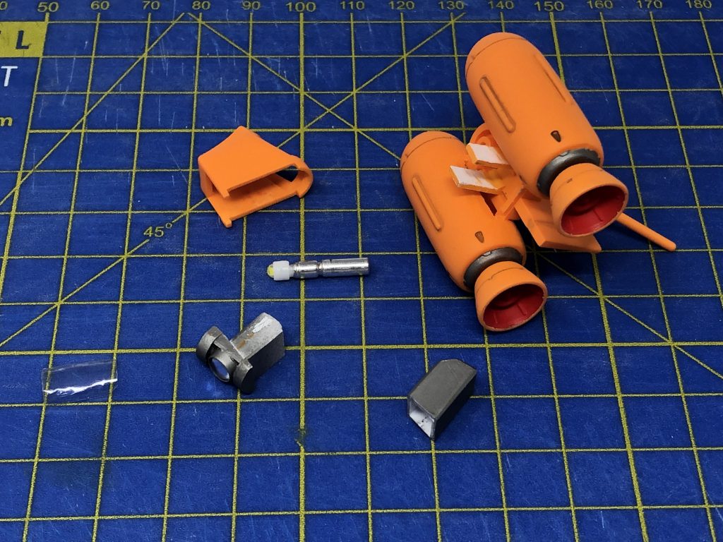 バックパックの電飾はこんな感じです。中央ブロックを切り離して前面をくり抜きました。ミライトはそのままだと長過ぎて入らないので、それを格納する入れ物と、Hアイズのレンズを使って潜水艇っぽいディテールを作ってみました。レンズカバーは透明なプラ廃材を再利用しました。ミライトは簡単に取り外せるのでスイッチのオン・オフや交換が容易になってます。中央ブロックの下側にはネオジム磁石を入れてあるので、ハイゴッグの背中側に埋め込んだネオジム磁石と接続できるようになってます。