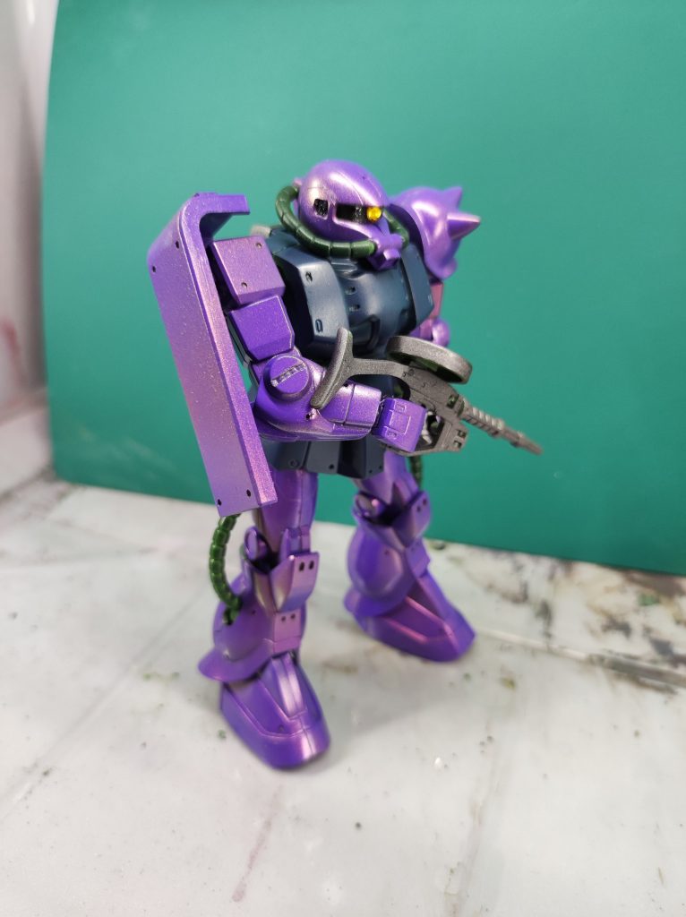 紫部分はガイアのパープルの上から、ミラーパウダーを混ぜたクリアを吹いています。ボディとパイプにはミラーパウダーは吹いていません。ボディがクレオスのディープオーシャンブルー、パイプが中島系の緑です。モノアイにはこれまたセリアのジュエルシール、をクリアボンドでくっつけてます。材料費めちゃ安ですね