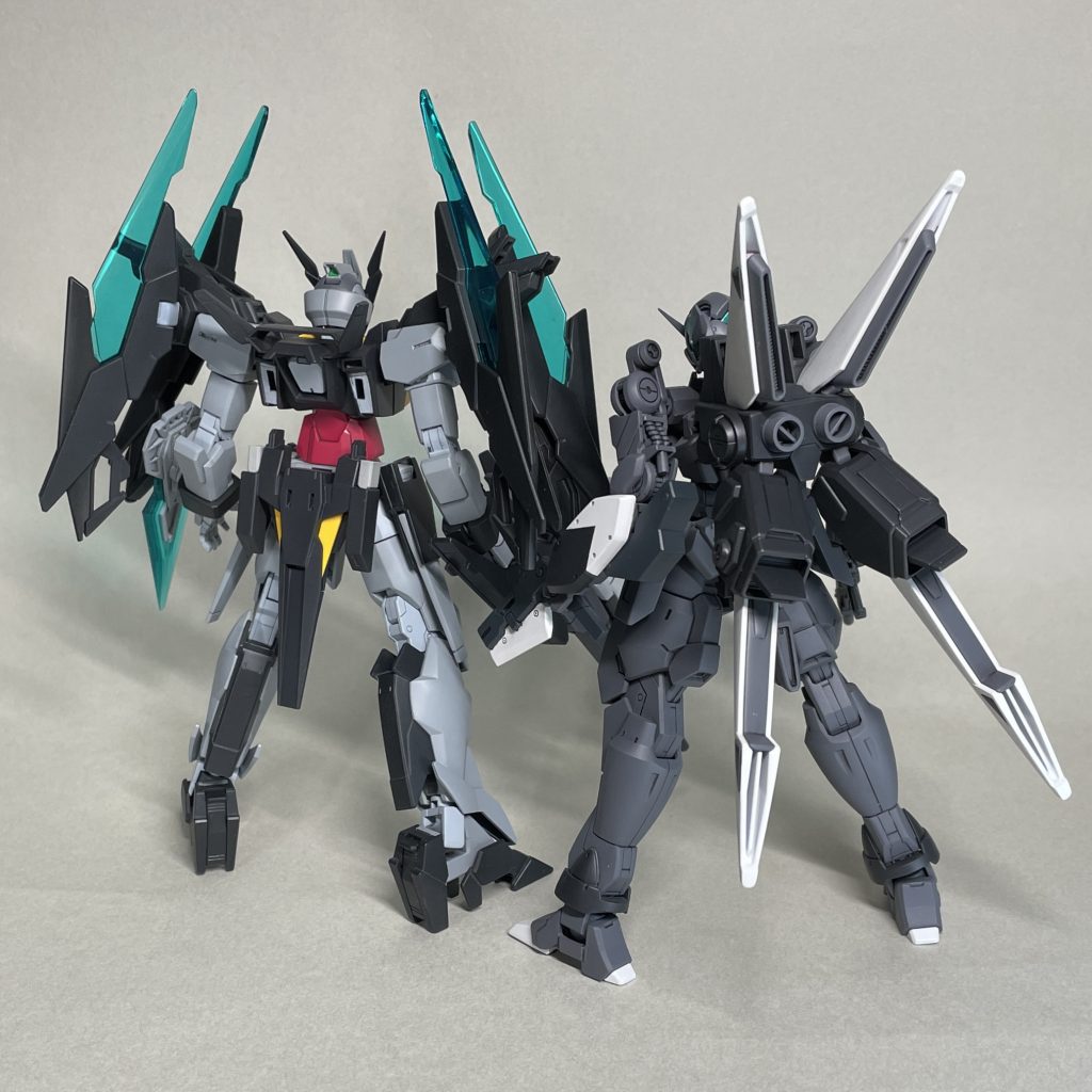 AGE2マグナム ＆ ビルドAサイフォス　うしろ　「ガンダムビルドダイバーズ」では「ガンダムAGE」登場機体は解禁されたものの、「鉄血のオルフェンズ」ベースの機体は登場していなかった気がするので、作品の世界観を重視するなら、厳密にはバルバトスの腕を用いた機体と並べるのはNGかもしれません。