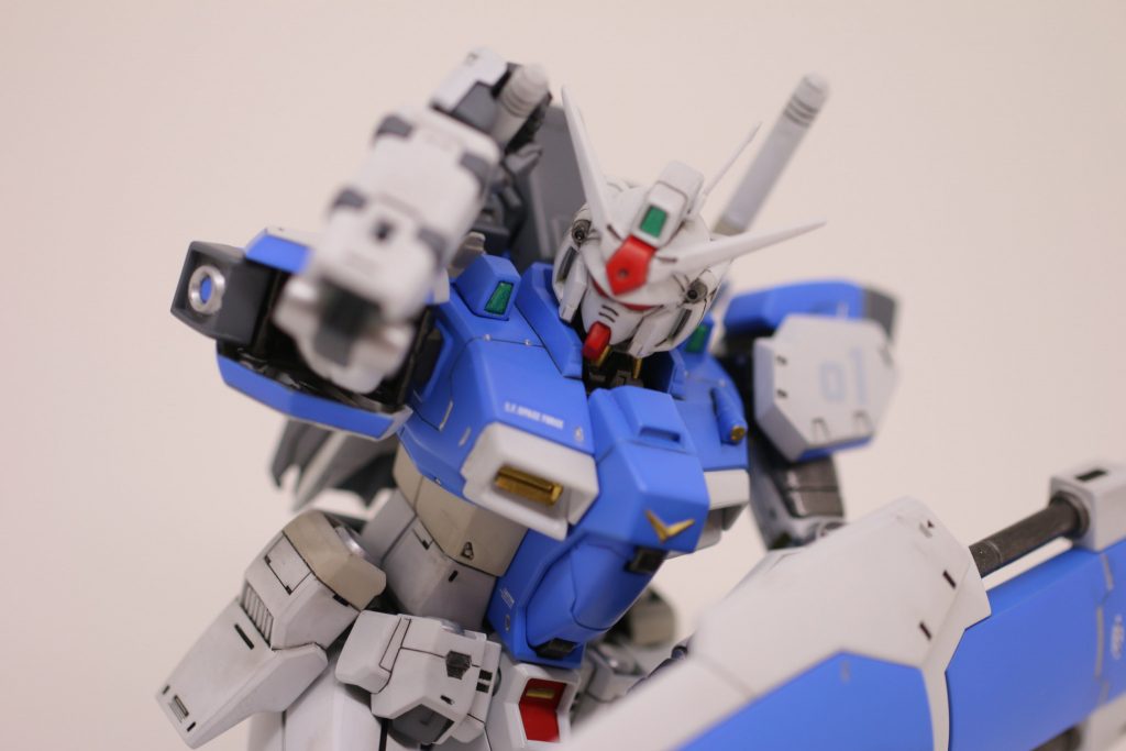 【ポージング：抜刀】　早速肩回りの可動。　ごらんのとおり、ショルディングしたビームサーベルを抜く動作を取れます（ギリギリ）。HGではなかなか難しかったりしますが、素組のままでこのポージングができるのは良いですね！　なお、地味に腰回りとサイドアーマーはツートンカラーにしています。「MS ホワイト」と「ライトグレー」での塗分けです。