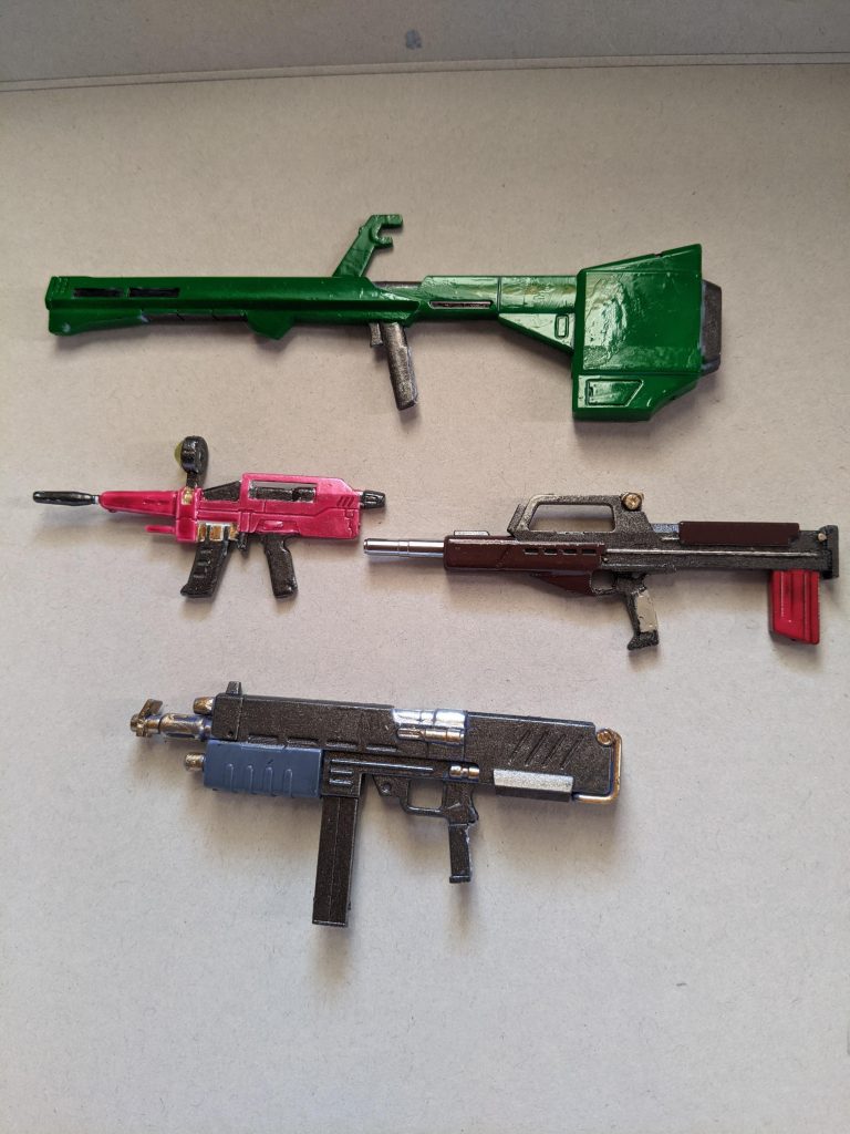 クレイバズーカ:バズーカは緑のイメージがあるので(なぜ)デイトナグリーンで塗装。ビームライフル:おもちゃ感をなくすために塗装をするものですが、あえて百均のおもちゃ感を出しました。ジムライフル:かなり好きな武器なので5色で真面目に塗装。銃口はシャーペンの先端パーツを移植しました。MMP80:こちらも5色です。グレネードランチャーが紛失したことが悔やまれる…