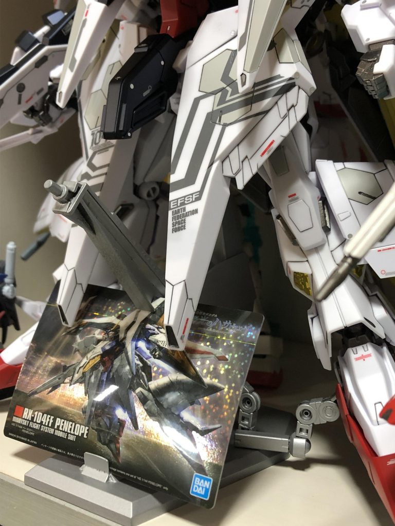 ガンプラパッケージアートお菓子のおまけカードを持ってるのを思い出して一緒に飾れるように仕様変更し、爪先を軽く伸ばした状態で床面に付かないギリギリの高さに調整、やはり股関節が足の重さに耐えれそうに無かったので補助アームも追加し、テキトーにシルバーで塗装して完成です。