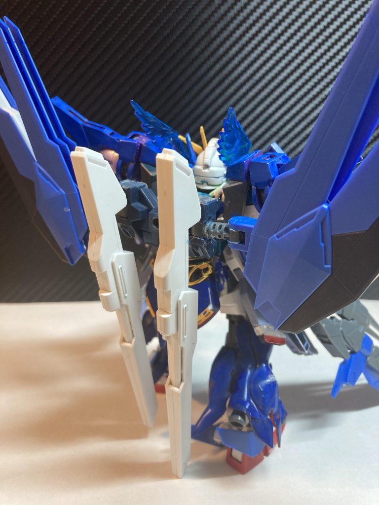 新型のバックパックはDXのツインサテライトキャノンにフリーダムのウィングを(強引であるが)組み合わせて完成させられた。これにより機体重量が増加しているように見えるがGN粒子によってむしろ軽くなっている。(ただしそれはGBNでの話であってリアルは倒れかそうになっている)