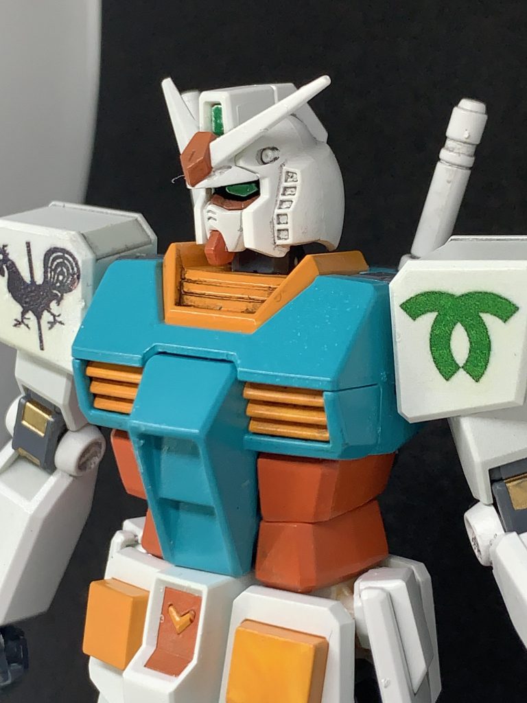 ガンダム本体は微妙に改造。EGガンダムを使用。頭のツインアイセンサの上に0.5mmのプラ板を挟み込み、ヘルメット部分を少し浮かせて顔つきを自分好みかつ優しめに調整。いわゆる目の部分の外側の空洞部分は外に面した目の部分以外を真っ黒にすることで空洞感を削減できたかも。