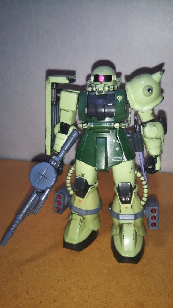 主人公、サム・ハーバート伍長機の正面素立ちです。 使用したキットはHGUC量産型ザク(正確には、61式戦車などの追加された「ザクⅡ地上戦セット」)です。  武装は旧HGUCグフに付属するMMP-78ザクマシンガンと、このキットに付いてくるヒートホーク、ミサイルポッドです。 実はキットに付属する手首パーツでは、グフのMMP-78ザクマシンガンをうまく構えることができません。 なので、手首はシステムウェポンに付属するモノに置き換えてあります。 造形的にもこちらの方がリアルな感じがするので気に入っています。