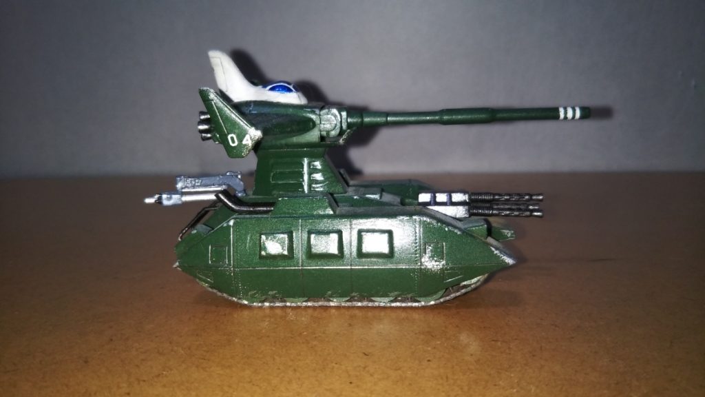 　サイドビューです。　そういえば説明が遅れましたが、塗装はザクのボディにも使用したグリーン、マゼラトップのコクピット（？）がツヤ消し白、機関銃やマフラー、手すりにスラスターなどは黒鉄色です。　マゼラトップのキャノピーは、銀色で下地を塗った上からクリアブルーを塗りました（いずれも水性ホビーカラー）。　これにザクと同様、黄土色のパステルをけずった粉を平筆ではたき、ツヤ消しトップコートを吹いてあります。　その後、全身にドライブラシやスポンジチッピングでウェザリングを施しました。　ちなみに、ウェザリングに使用したのは銀色です。　また、マゼラトップの左右には小隊番号（04）をデカールで張り付け、砲身には白いラインをマスキングして描き込みました。　個人的に、戦車はあまり注意書きなどがあるイメージがないので、ザクに比べてマーキングはかなり控えめです。