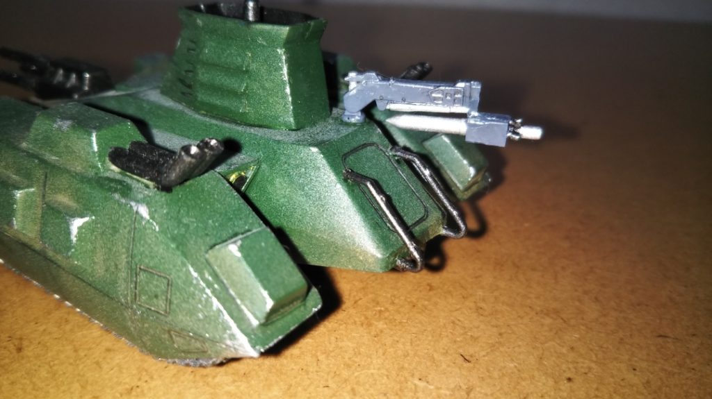 　お待たせしました！　追加装備のアンダーグラウンドソナーです。　このマゼラアタックの操縦手、トモヤ・ハセガワ軍曹は、優秀な戦車乗りであると同時にソナー手としても小隊を支えているという設定なので（この設定自体は、高校生の頃にこの小隊のストーリーをノートに落書きしていたころからありました）、プレバンで購入したジム・スナイパーⅡ（ホワイトディンゴ隊仕様）に付属するホバートラックから移植しました（なお、畳んだ状態を再現するため、もともとは展開状態だったパーツを一旦切り離し、向きを変えて再接着してあります）。　以前の投稿で「中破させた連邦のホバートラックから奪ったソナーを無理やり載せてある」という設定を設けてあるのもそのためです。　無理やり後から追加した装備、ということを強調するため、塗装はあえて本体とは全然違うミディアムブルーにしてあります。　取り付け位置はいろいろと考えたのですが、後部ハッチ付近なら内部に多少ソナーの機材を追加する余裕があるのではないか、と考え、ここにしました。　しかしながら、やや性格に難があって口の悪いソナー手という設定は、今思えばまんま08小隊のエレドアのパクリですね(笑)。