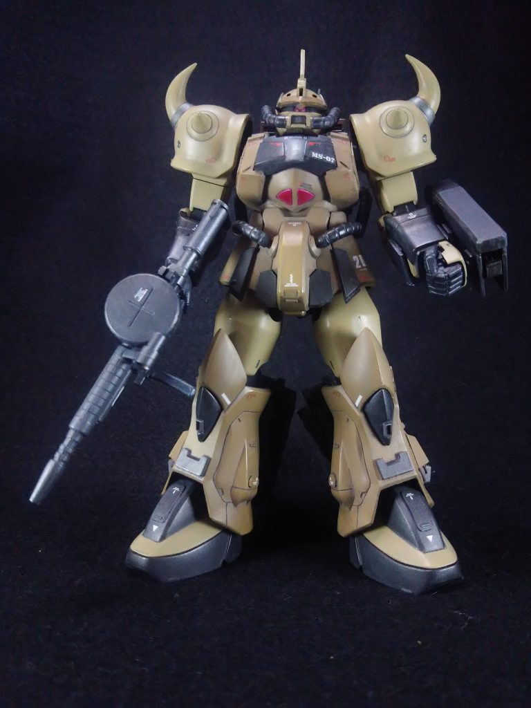 乾燥と灼熱の大地アフリカ砂漠。この大地にも人々は糧を求めて足を踏み入れ開拓をしていた。 宇宙に拠点を置くコロニー国家ジオン公国。地球侵攻作戦を行なった理由の1つは地球連邦軍の本拠地を叩く事。そして資源の調達である。 このアフリカ戦線では勢力圏の拡大と資源奪い合いが常に行なわれていた。 そんな砂漠の戦場に今、3体の巨人が永遠と思える砂の大地に影を落す。 「少尉!新型の乗り心地はどうでありますか?」 左後方を歩くデザート・ザクのパイロットがなんの変わり映えの無い風景に遂に我慢ならず、そんな軽口が口を吐いた。 「軍曹、貴様分って言っているだろう?」 先頭を行く新型機。正確には試作1号機のデザート・グフのパイロット、グライム少尉が苦い顔をして見えない軍曹の顔を睨む。 戦闘中に高速で動いてる分には気にならないのだが、こうやって他のMSに合わせて低速で走ってるとその振動は決して快適なものではなかった。 こっそり厚手のクッションを尻に敷いてるのだがまだ足りない。 (ここの改善は最初に言ってたのだがな・・・) 試作型砂漠用MS、MS-07D『デザート・グフ』 まだ仮称のこのMSの実戦テストの為、デザート・ザクを2機従えてグライム少尉はこのMSの脹脛に追加されたキャタピラユニットからの振動に耐えていた。 「少尉、そろそろ作戦ポイントです」 もう1人の伍長がモニターに表示された地点に近付いたことを知らせた。 「ああ、」 周りを見回して、グライムは指示を出す。 「よし、ではここに潜伏して敵を待つ。潜伏後は通信は切れ」 「「了解!」」 デザート・グフはキャタピラユニットから下りるとそのユニットを地面に突き刺した。 そのままキャタピラを回転させて地面の砂を掘り始める。さらに脚部スラスターを使って砂を吹き飛ばして徐々にデザート・グフは砂の中に消えていった。 デザート・ザクもスラスター等を使って潜っていくが、グフより時間が掛かっていた。 完全に砂の中に潜ったデザート・グフは頭部に装備したグランド・ソナーをONにして、静かにその時を待った。