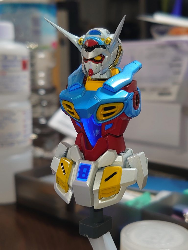 塗装レシピは以下の通り胸部など(青系)は下地は黒→白→MGパール入りクリアー、その上にクリアーブルーをクリアーで2.5倍に希釈したもので２回塗り脚部など(白系)は黒下地の上に白に極少量グリーンを混ぜたものにMGパール入りクリアーでパール塗装赤色は黒下地の上に素のガンダムレッドを塗りました黄色は白下地の上に、イエローに少量のオレンジイエローを混ぜたもので塗装しました。クリアパーツはUVライトで発光。クリアパーツ以外で発光してる部分はエナメル塗料のスカイブルーにグリーンスタッフワールドの蛍光ブルーのピグメントを混ぜたものを塗ってます。