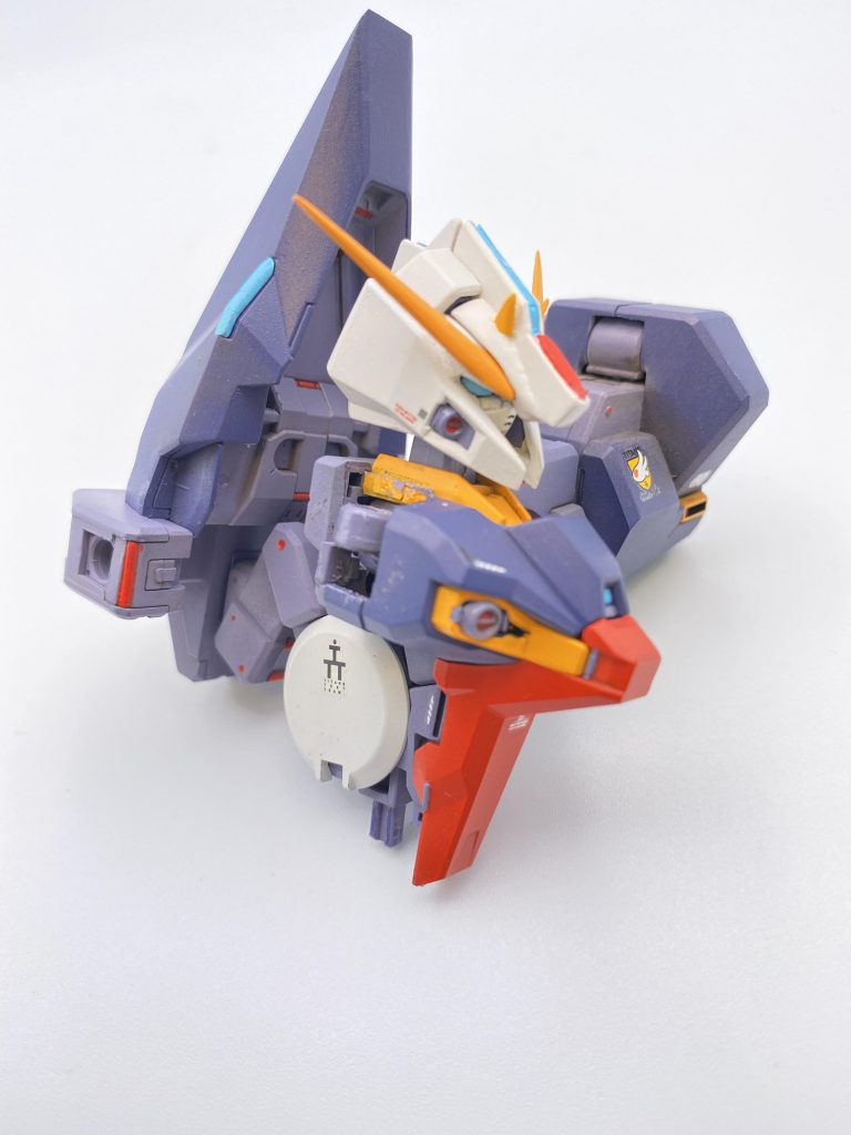 以下、製作記録・頭部…正面を向いている同機体のイラストを元に全体を改修。プラ材やパテで角、ひさし、目つき、インテーク縁の厚み、頬角度を変更。胴体…肩関節をウーンドウォートのパーツから新造。また上側ドラムフレームの稼働範囲を拡大、これら2つの工作で胸を張ったポーズが出来る様に。背部ブースターポッドの縁をシャープ化