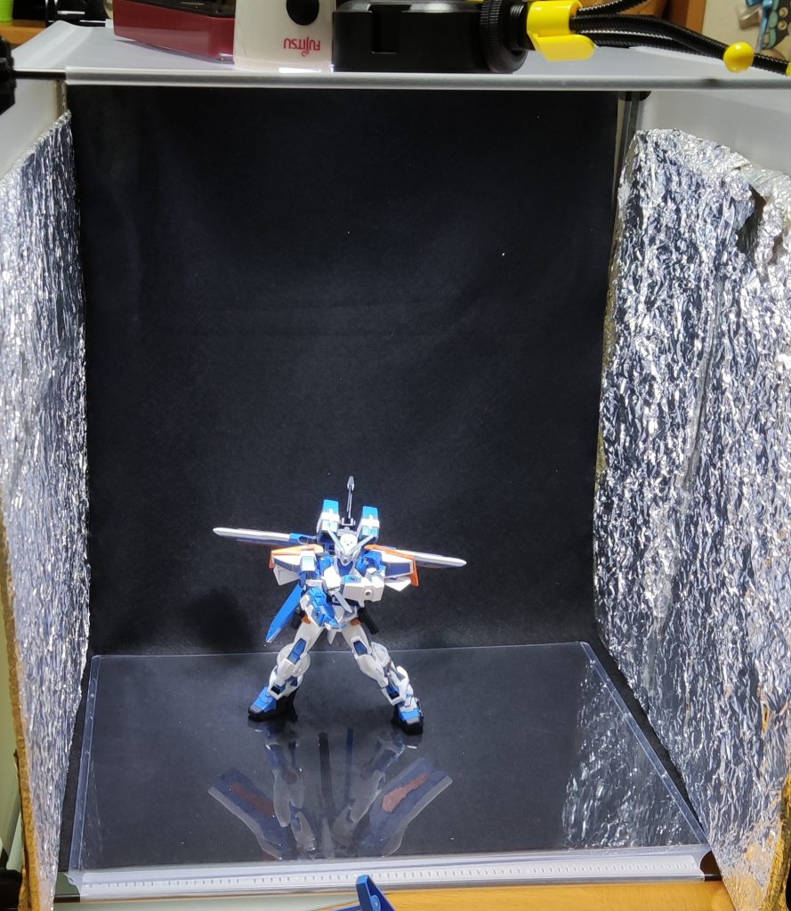 百均で買った棚とライトと黒のフェルト生地。アルミホイル、家にあった懐中電灯、アマゾンで買った撮影用の光源を使ってブースを作り、スマホで撮影してます。