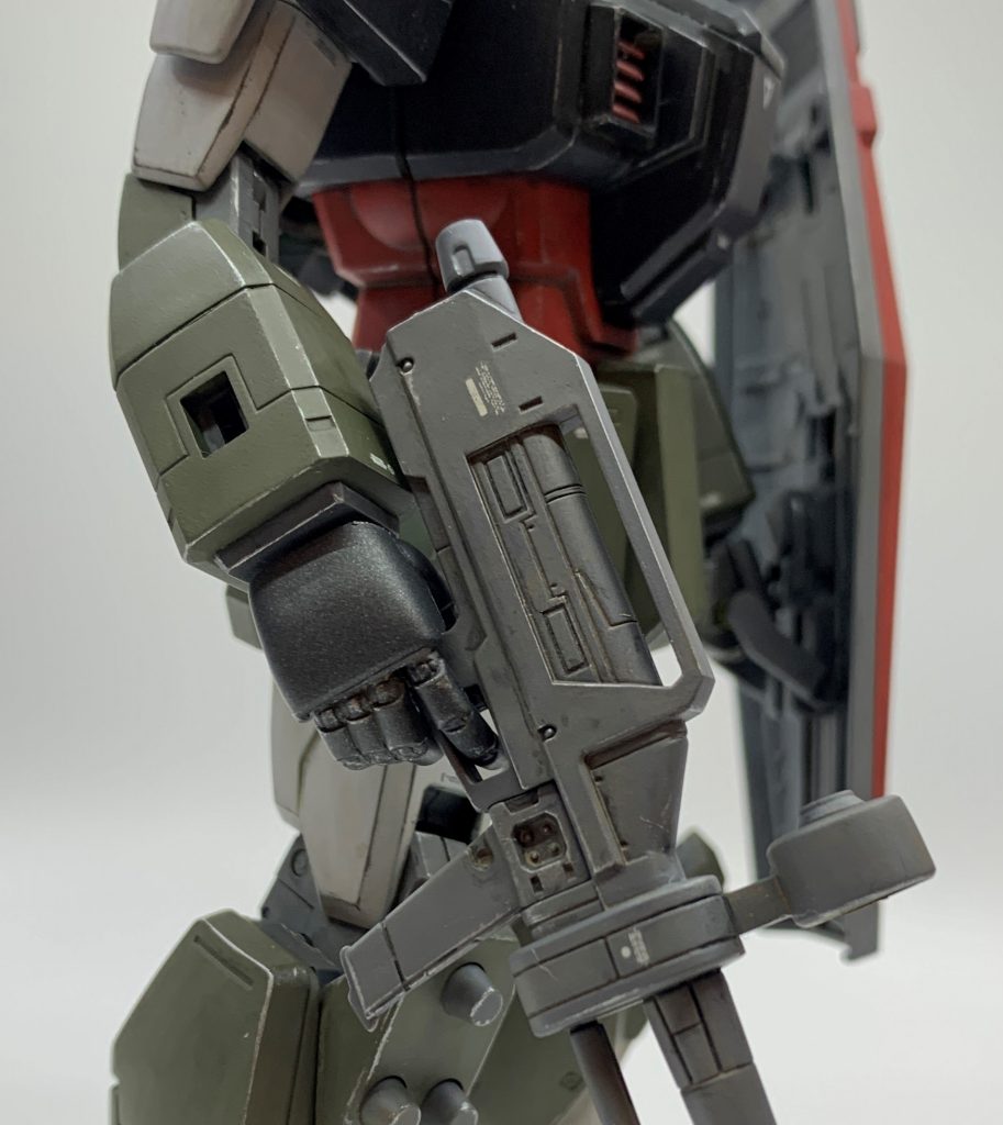 本キットの手首は旧いMGによくあるPC素材で、造形甘い、表面処理綺麗に出来ない、塗料のノリが悪いという三重苦なので、手っ取り早くサードパーティ品に換えました。リアルタイプカラーに合いそうな、丸みを帯びてちょっとしたレトロ感を醸し出す造形の手首を選びました。シールドの持ち手はサードパーティ品で賄えなかったので、キットの握りこぶしを加工して握らせています。シールドの取っ手にマスキングテープを巻き保持力を調整しました。