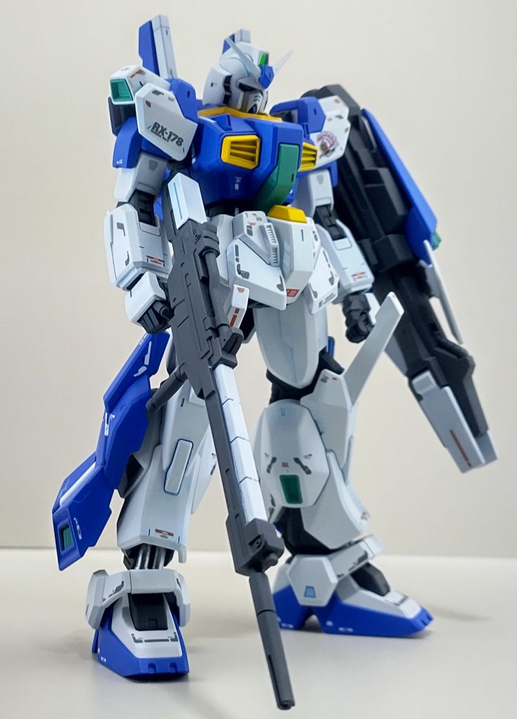 そしてもう1つの過去。更に前AEのテストパイロット時この機体と同じ色で塗装されたガンダムの記憶。その機体は「開花」の名を冠されていて、当時の最新技術を詰め込んでいたがパイロットへの負担が強すぎた事と計画自体が無くなり幻となったのだ。しかし彼からしたらその機体に乗ったことで降格させられた上にパイロットとしての技量不足に泣かされた苦い思い出が蘇ってくる。