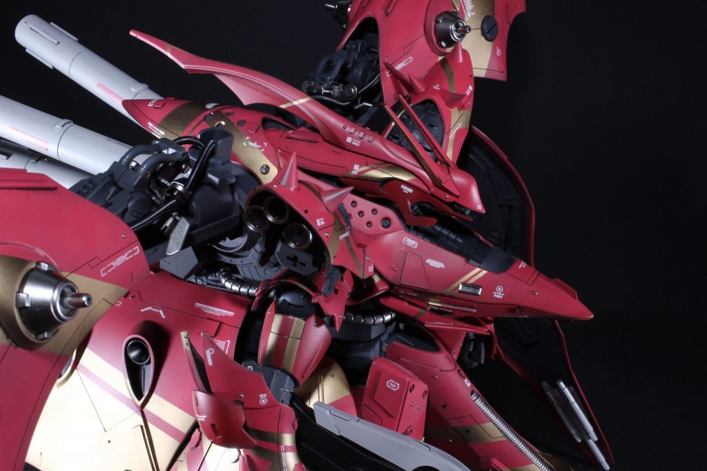 黒背景にて。外装パーツは4点除いてすべてマスキングし、その場の思いつきで貼っています。ちなみに、黒サフ→ゴールド→マスク→ゴールド下地のままレッドを吹いています。肩にはコトブキヤスパイクパーツを使用、関節部は可能な限りメカぽく、主にRGサザビーのパーツを流用してます。