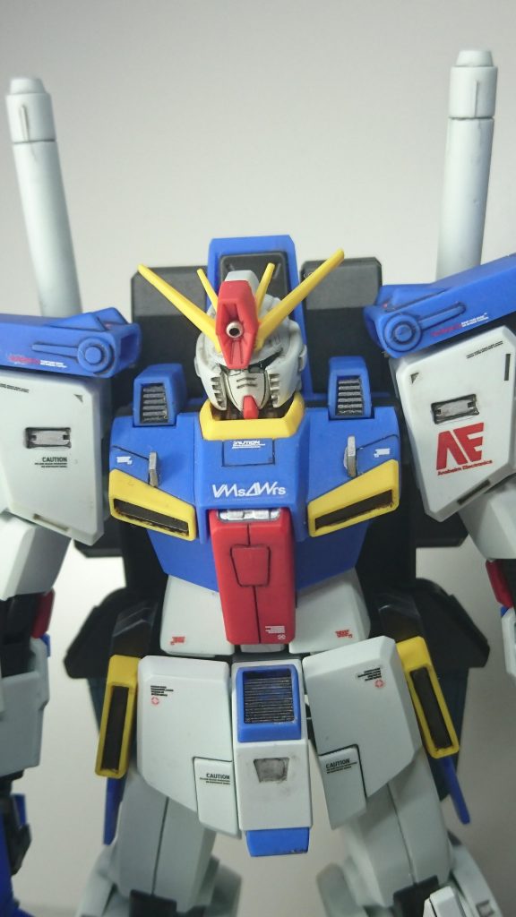MGとの違いを感じた頭部ですが、頬のダクト部を薄くなるように削り、カメラアイの上部のひさし部分は逆に狭く感じたのでプラ板を2枚接着して削り大きくしました。フェイス部は大きく感じたので顎を削りなるべくヘルメットの奥側に入れて小顔に見える様に再接着、ハイメガキャノンは真ん中に何時ものプラビーズを入れて若干下部に再接着しました。首も短くしています。胸元にランナーをカットしてフィンみたいな物を接着しました。