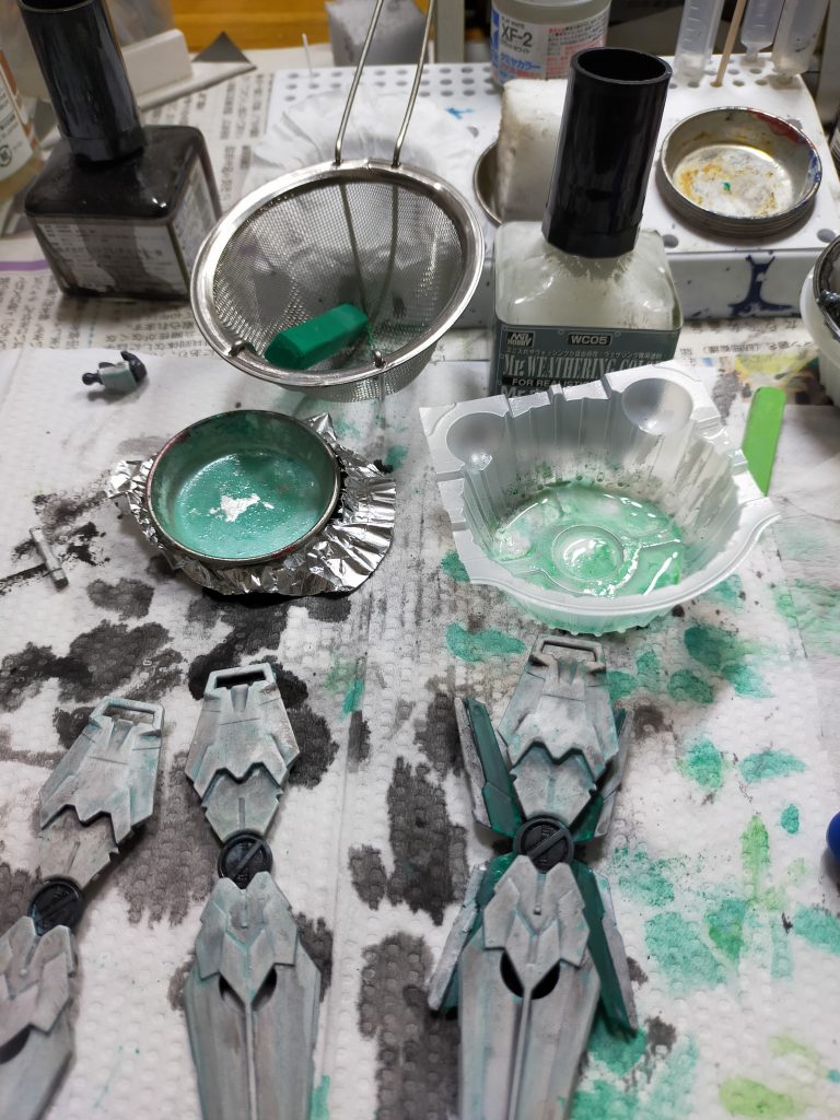 緑のサイコフレーム部分は、タミヤエナメルのクロームシルバーのう上からタミヤアクリルのクリヤーグリーン。本体部分についてはトップコートがかなりムラがある状態で乾燥していましたので、あえてそのまま。下地に黒サフ→タミヤカラーのフラットホワイト。ウエザリングカラーのマルチブラックでスミイレとグラデーション。その上にマルチホワイトに100均のパステルの緑を茶こしでこしてみました。