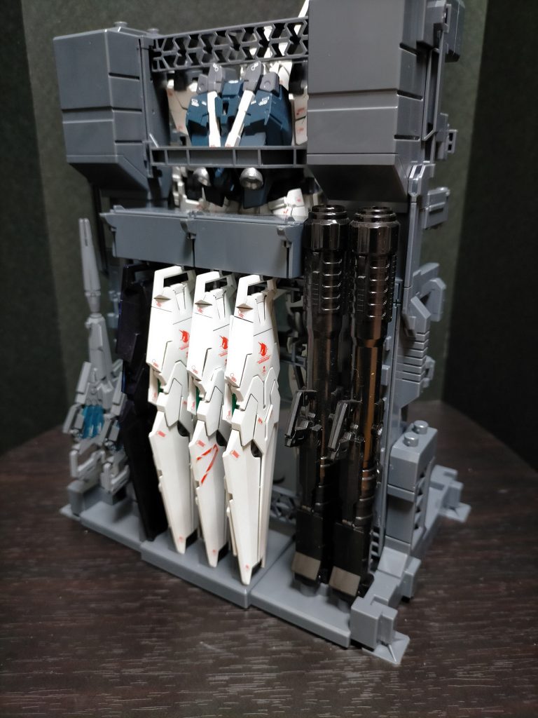 背面武器ハンガーBEAMSマグナム×2     シールド×4バズーカ×2    床裏にビームサーベル刃×2分の収納と、シールド上の箱が小物パーツ収納になっています。フルアーマー分の武装は乗り切りませんが、武装収納がしてあると格納庫感が増していい雰囲気です。※MS、武器等は別売りです（笑）