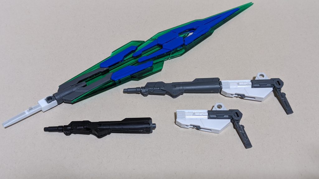 「クアンタのガントレットはスサノオのガントレットと同じく片手使用時にバスターソード使用時のエネルギー負荷を軽減する役割があるのではないか」という解釈から、ガントレットがないなら片手じゃなく両手で負荷を分散すればいいと、GNソードVのライフルモードをオミットしつつ両手で持てるようにビームサーベルを加工した長い柄を作成。GNソードビットとGNソードVの刀身には手を加えていないのでもちろんバスターソード形態も可能。ただし、ライフルモードはオミットしたのでバスターライフル形態は不可。構造的に先端は開きますが、GBNチャンプや大貝獣の召喚王みたいにカードを挟んだりはしません。低下した射撃能力はシールドバインダーに取り付けたバレルをGNガンソードに取り付けることでツインバスターライフルモードに変更可能。バスターライフルを使用しつつソードビットも使用できるお得仕様。 機体名の7Sは勿論セブンソードですが、2Bはこのツインバスターライフルから、またはすべての武装を合体させることでバスターソードとバスターライフルの2つが完成するところからです。今考えました。