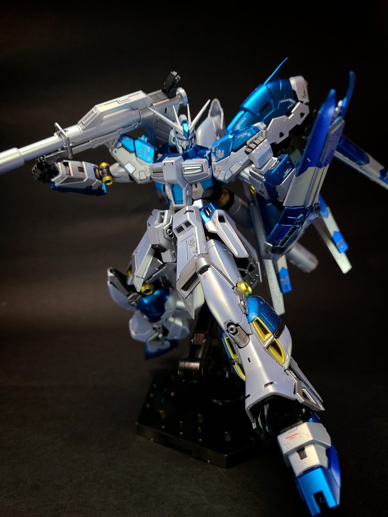 デザイン (ベルトーチカ・チルドレン版Hi-νガンダム)2007年にサンライズ主導で行われた公式設定化の際、出渕により再デザインされ体型や各部の配色などが一新された。マスターグレード(2007年版)やHGUC版[60]の組立解説書では、νガンダムの強化発展型としての設定ではなく、小説『ベルトーチカ・チルドレン』に準じた設定解説がなされた。特徴としては、2000年代のトレンドに合わせ全体的にスレンダーなスタイルであり、青と白を基調にして各部にシルバーとゴールドのアクセントカラーを用いている。デュアルカメラはイエロー、胸部ダクトはシルバー、シールドは青と白のスプリッター迷彩、フィン・ファンネルは青一色である。差し色にシルバーとゴールドが用いられている。プロペラント・タンクは細く短めになり、スタビライザーはZガンダムのものに近い。右腕部にはマシンガンが追加された。2014年に月刊ガンダムエースに連載された漫画版『ベルトーチカ・チルドレン』、サウンドドラマ版(復刻CD[62])でもこちらのデザインを採用している。