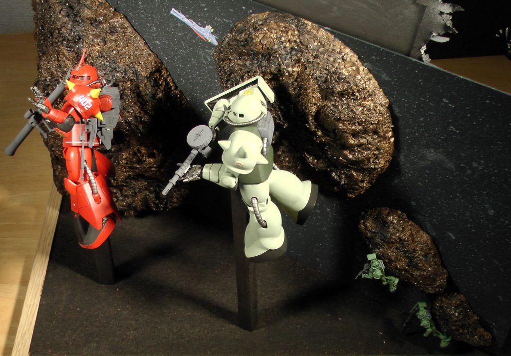 背景の岩は発泡スチロールでつくりました。すぐ後ろの僚機はザクマインレイヤーのノーマルモードです。マゼランとサラミスは旧キット箱絵のカラーコピーです。