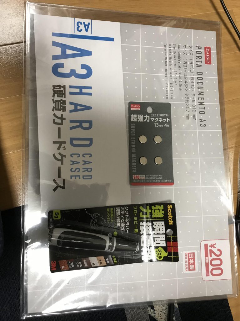 材料は、ホームセンターに売っている本棚。A3硬質カードケース(本棚にピッタリサイズです)、超強力マグネット、多目的フック、大きめの吸盤、瞬間接着剤。