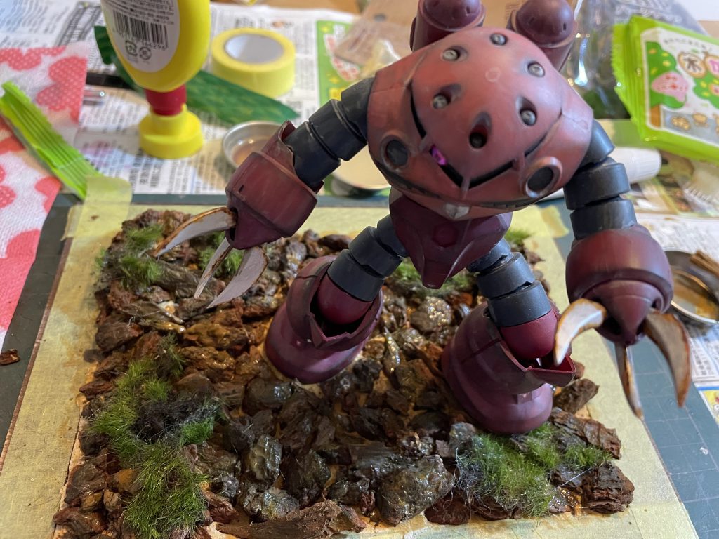 粘土を敷き詰めて足位置を決めてチップを埋め込みながら適当な所に草を木工用ボンドで貼り付けその後は水性絵の具で暗い色をつけ仕上げて3日位乾燥させて完成。